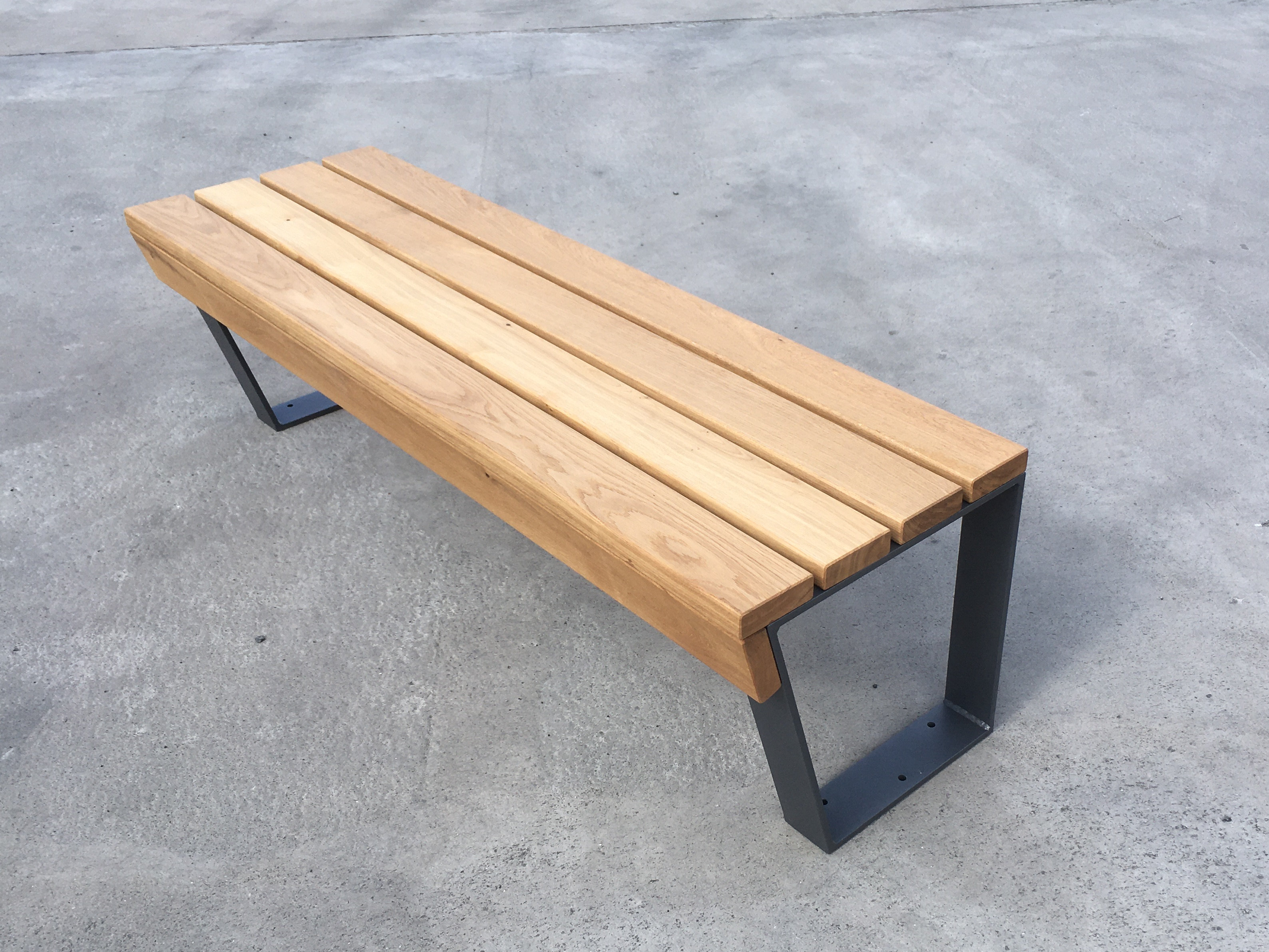 Bank ohne Lehne, mit Stahluntergestell und Auflagehölzern aus Eiche. Passend zur Sitzgruppe Typ "Holz-klasse!"